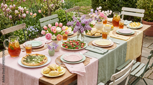 Spring food social gathering with fresh flowers and iced tea set on garden table for delightful outdoor meal with friends and family
