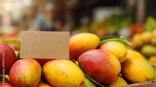Fresh mangoes with blank price sign at market, food price and cost concept