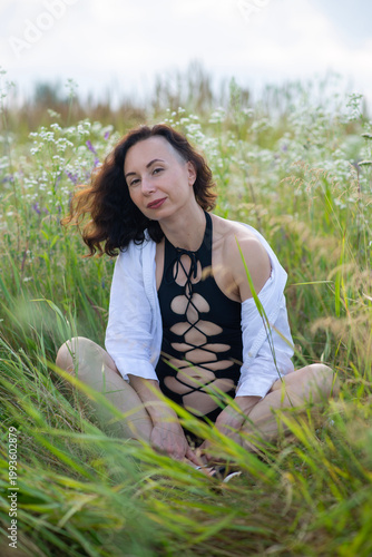 Woman in Black Cut-Out Swimsuit Sitting in Wildflower Meadow