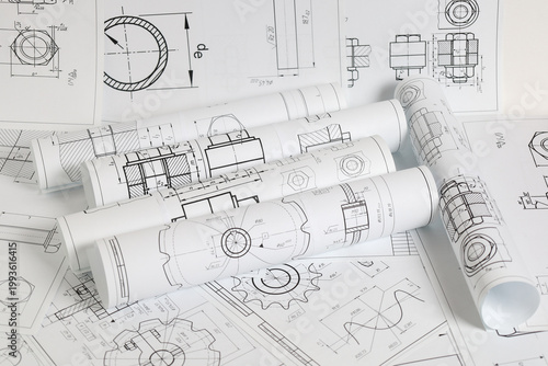 paper engineering drawings of industrial parts and mechanisms