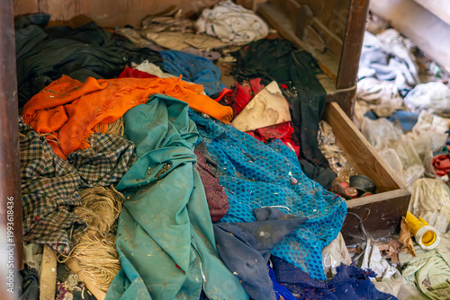 Canvastavla Messy drawer filled with old colorful fabrics and clothing in an abandoned house, material textures, concept of neglect and clutter, closeup of debris and junk in old furniture