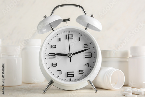 Pills and alarm clock on wh...