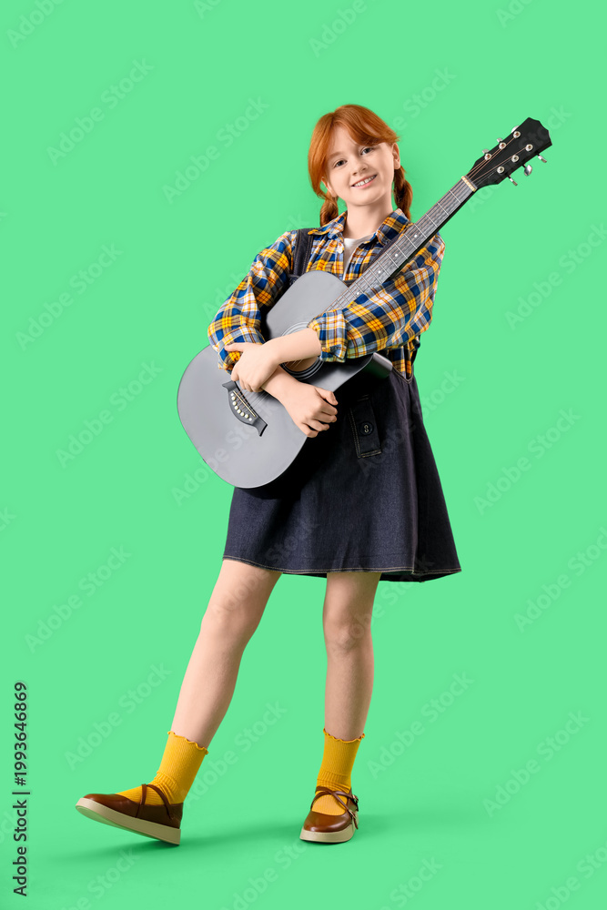 Fototapeta premium Redhead teenage girl hugging guitar on green background