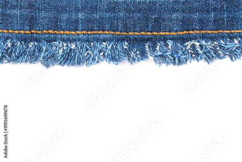 Photos Denim fabric with frayed edge shows the texture and detail of a casual wear item