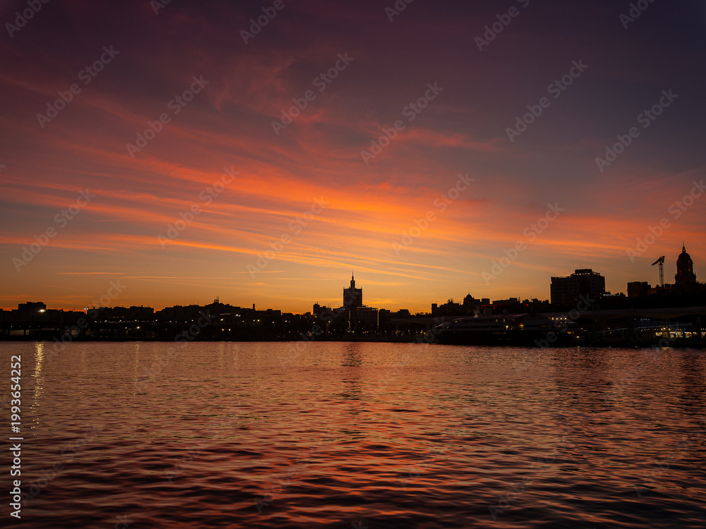 Naklejka premium Malaga city skyline at vivid twilight sunset