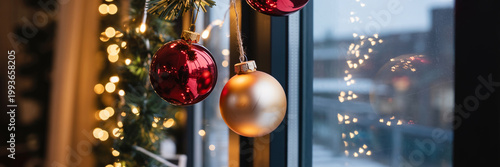 Christmas Baubles Hanging on Window with Warm Bokeh Lights and Night City Background