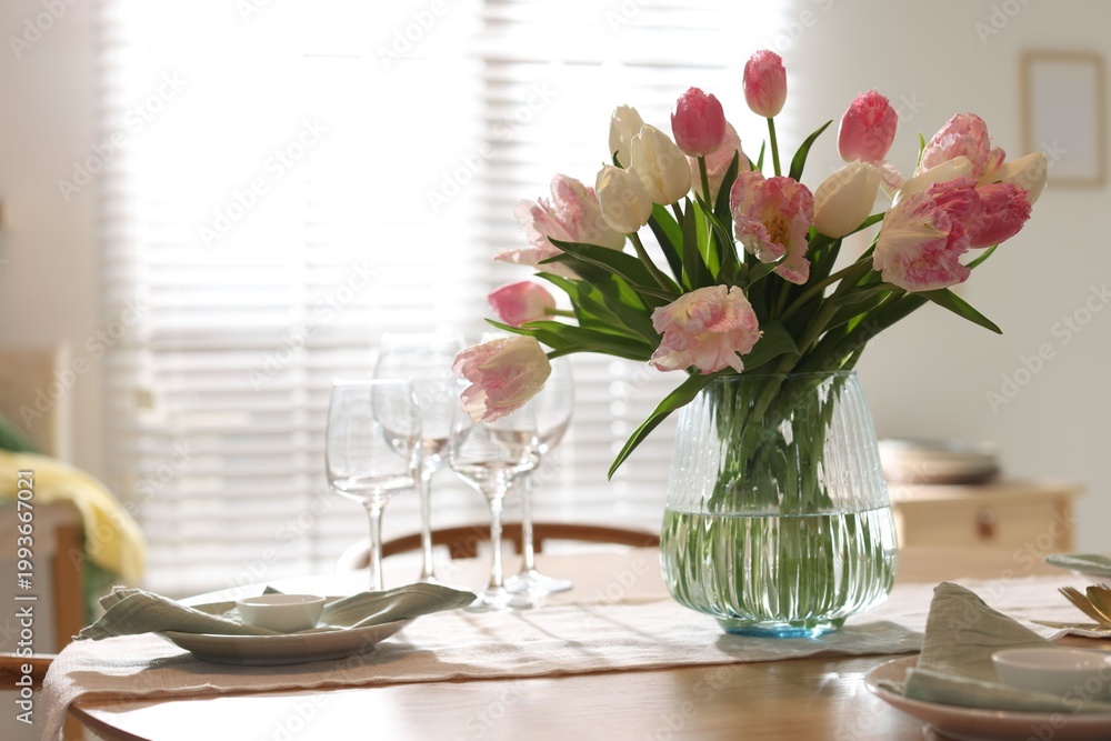 Obraz premium Stylish table setting with beautiful tulips, dishware and glasses in dining room