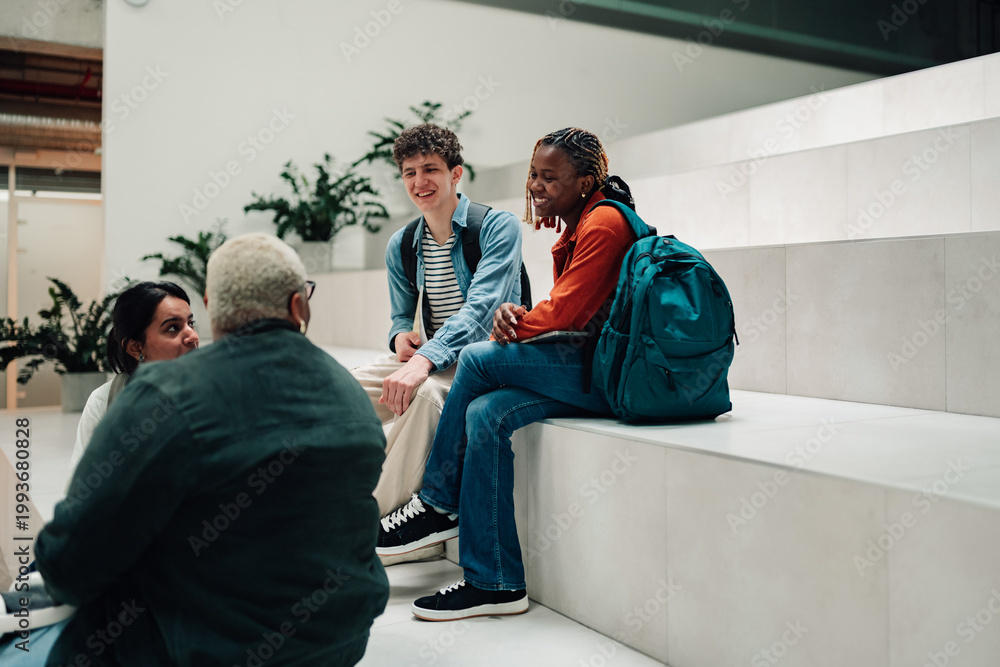 Naklejka premium Diverse students talking and networking on college campus steps, enjoying social interaction during a break from studies