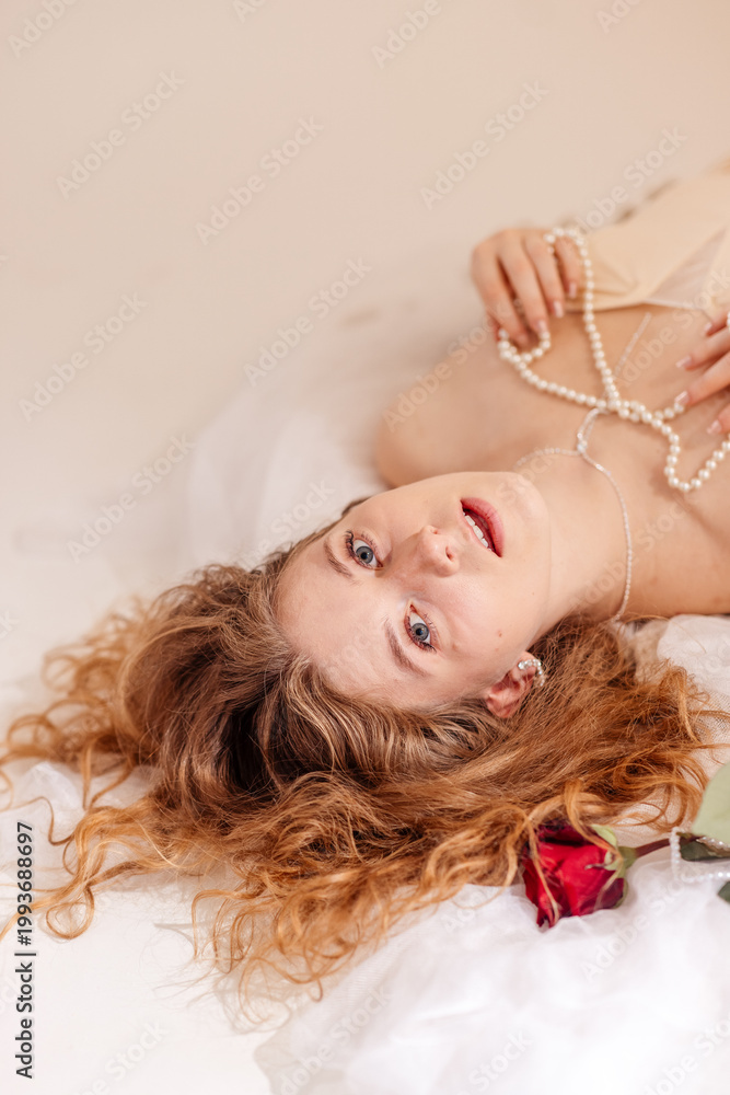 Naklejka premium Stunning portrait of a beautiful young woman with long voluminous curly hair posing in a professional photo studio, beauty and fashion concept, Prague, Czech Republic, June 2025