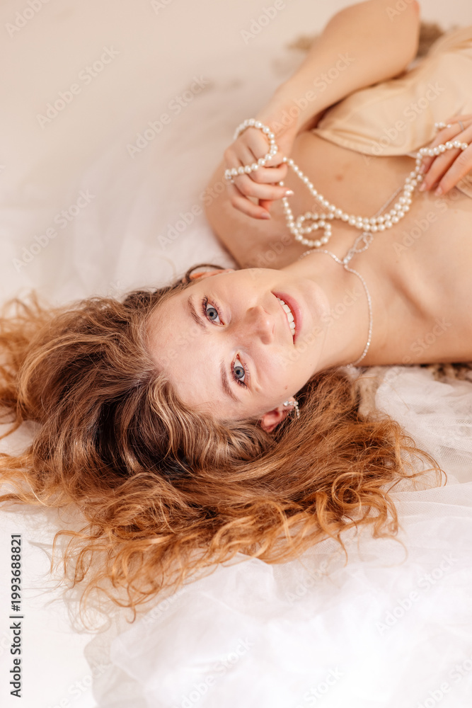 Naklejka premium Stunning portrait of a beautiful young woman with long voluminous curly hair posing in a professional photo studio, beauty and fashion concept, Prague, Czech Republic, June 2025