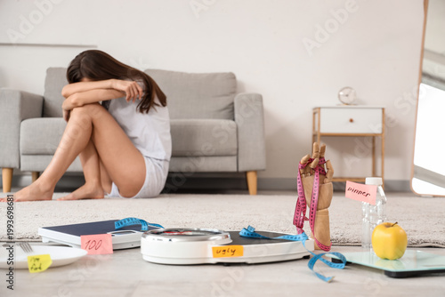 Konstfotografi Weight scales with tape measure and food against upset woman at home