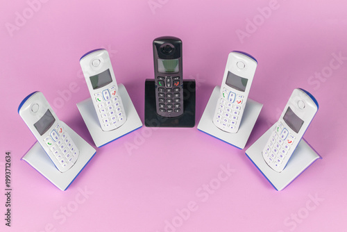 Retro Cordless Phones Displayed in a Circle on Pink Background