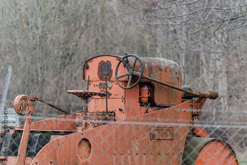 Old rusty agricultural machinery on field in natural environment.