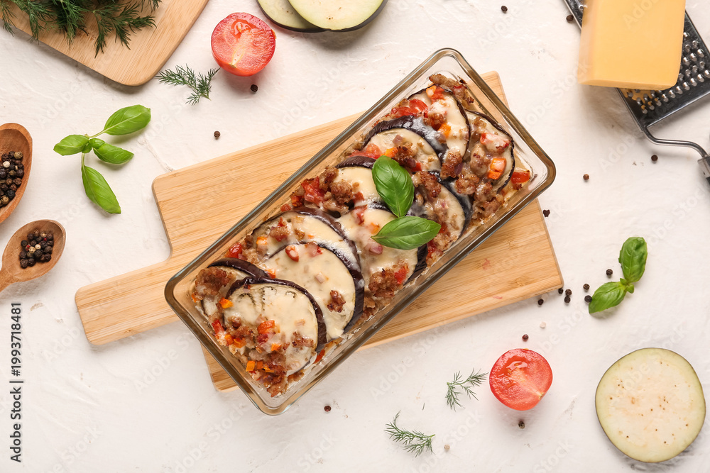 Naklejka premium Baking dish with eggplant slices, ground meat, vegetables and cheese on light background