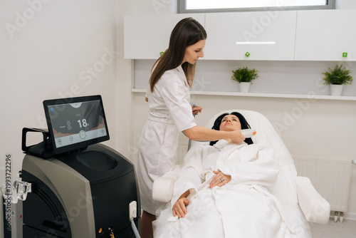 Quadro em tela Relaxed middle-aged woman receiving modern hardware cosmetology procedure for facial skin rejuvenation from beautician, non invasive treatment for antiaging and skin tightening in beauty salon