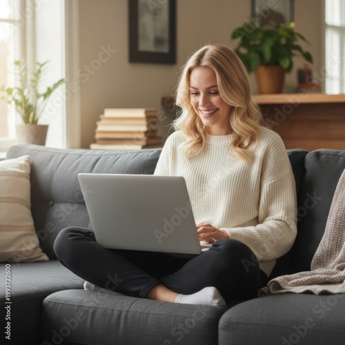 Young woman using laptop while sitting on sofa at home