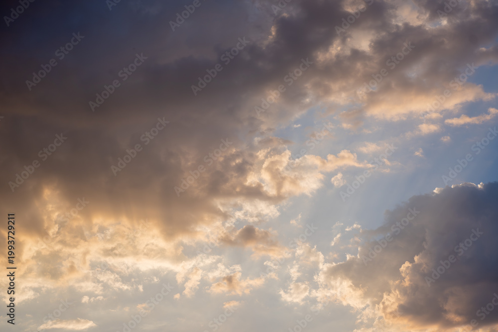 Fototapeta premium Dramatic Sunset Sky With Golden Sun Rays Breaking Through Dark Storm Clouds