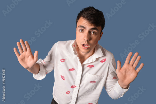 Canvas-taulu Shocked man with kiss marks on his shirt against dark blue background