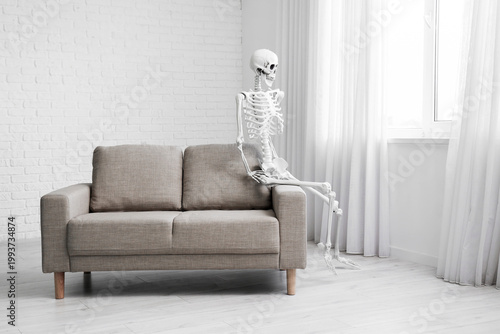 Skeleton sitting on sofa in...
