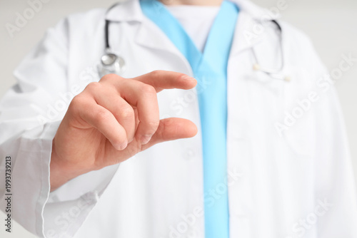 Photos Male doctor holding something on light background, closeup