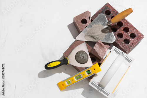 Tableau sur toile Bricks, plastering float and trowels with cement on white grunge background