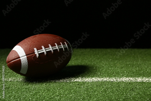 American football ball on g...