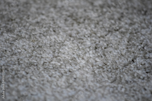 High angle view of grey wool carpet fibers. Soft fabric texture for interior design, home comfort, and flooring background. Macro shot of fluffy textile material.