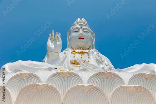 Photography Large seated goddess statue white Wat Huay Pla Kang overlooking temple complex on hilltop in Chiang Rai, Thailand