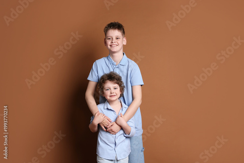 Obraz na płótnie Portrait of cute brothers on brown background