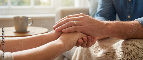 support comfort care holding hands empathy warmth cozy home connection warm handholding beside a coffee mug shows reassurance empathy and calm connection for counseling wellness and home care themes