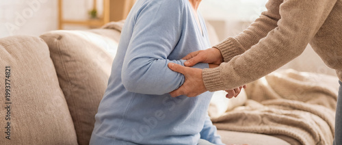 caregiver support senior help comfort safety empathy home care warmth gentle help while rising from the sofa shows patience compassion and care for rehabilitation recovery and supportive living themes