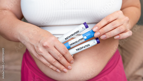 Woman holding GLP-1 injection pens semaglutide tirzepatide retatrutide on abdomen, weight loss and diabetes treatment concept, close up with copy space