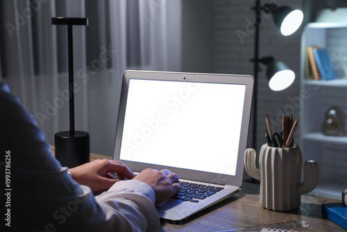 Woman using blank laptop on...