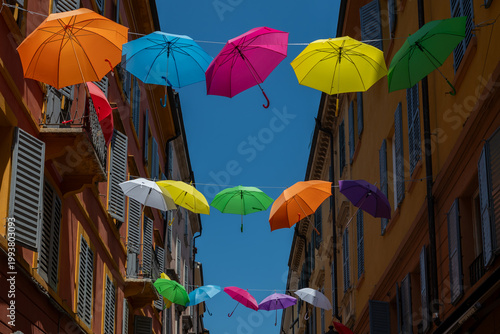 Colorful umbrellas in the city .City street in Modena, Italy with rainbow colored umbrellas overhead, vibrant urban scene, summer atmosphere, travel destination