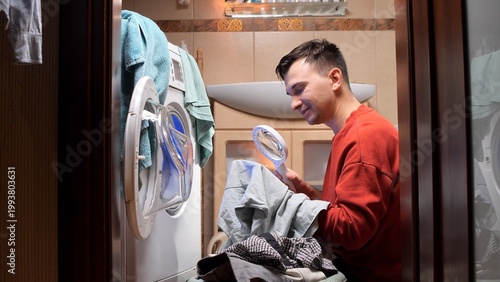Fotografi Man carefully inspecting a piece of clothing with a magnifying glass before wash