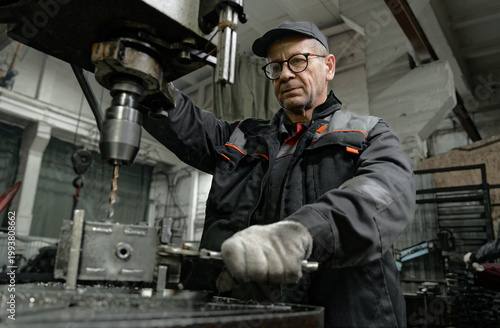 Professional engineer performing metalworking operation in workshop