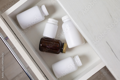 Bottles of vitamins and mineral supplements are stored in a drawer.