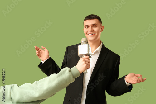 Young man and hand with mic...