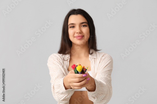 Beautiful young woman holdi...