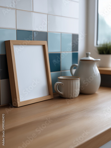 Blank wooden picture frame on a kitchen counter with a mug and pitcher