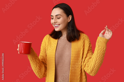 Happy young woman with cup ...