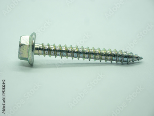 A professional close up shot of a single hex head flange wood screw isolated on a clean white background.