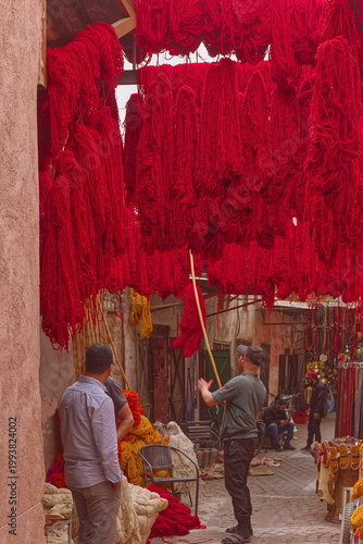 Red-dyed (some in ochre) wools and silks hanging to dry above the street in the Souk des Teinturiers (dyers) in the Medina. Marrakesh-Morocco-317
