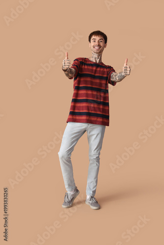 Happy young man showing thu...