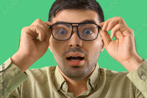 Afraid young man in eyeglas...