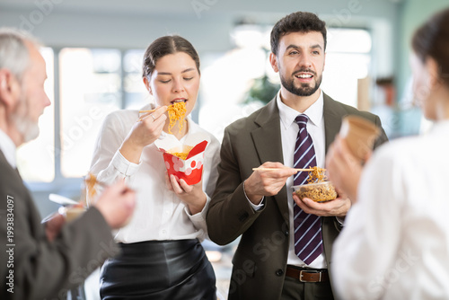 Billede på lærred Group of friendly young office workers different ages standing and eating fast f