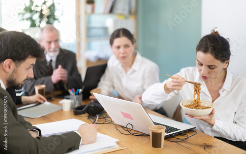 Фотография Office staff are indignant because of unpleasant smell of food and resent for eating female colleague