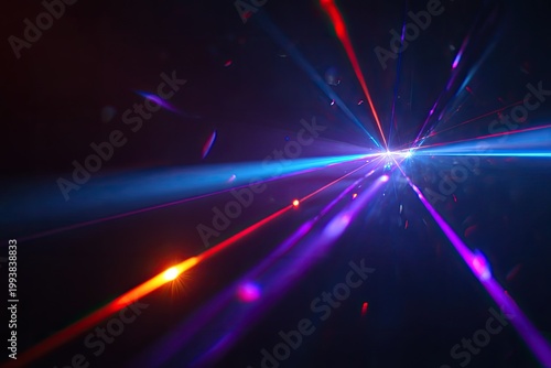 Vibrant intersecting laser beams radiate through a dark space with light flares
