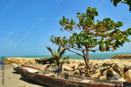 Aventura en el mar caribe: Canoa de madera navegando bajo un cielo azul despejado, concepto de libertad