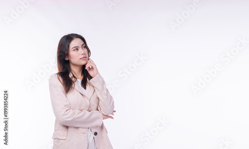 Thoughtful young Asian business woman in casual suit touching chin and looking away. Isolated on white background with copy space. Thinking, planning, and decision making concept.